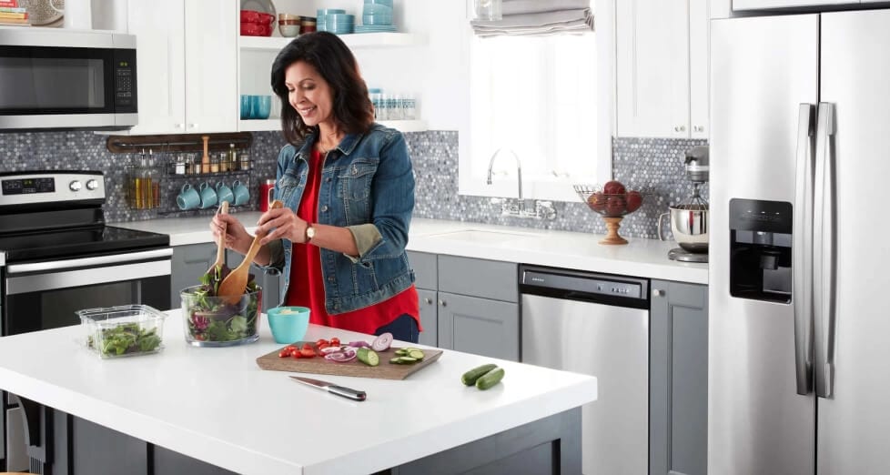A person preparing a salad in a kitchen.