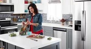 A person preparing a salad in a kitchen.